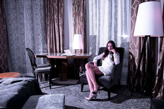 Das Bild zeigt eine junge Frau in einem Hotelzimmer.