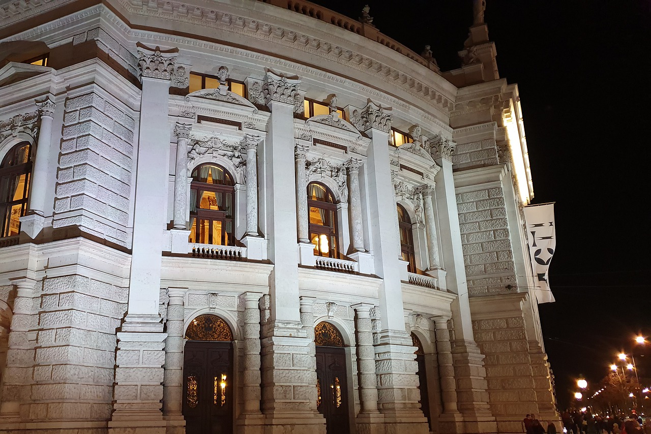 Das Bild zeigt das angeleuchtete Burgtheater in Wien.