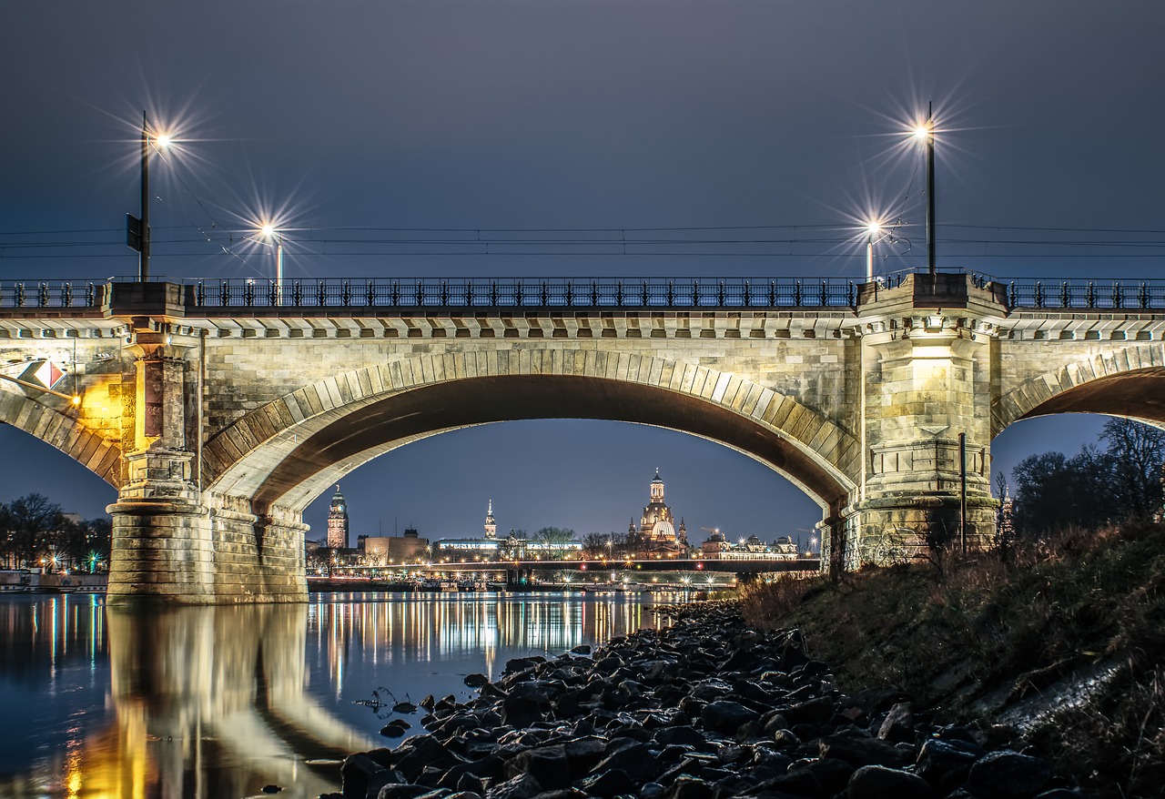 Das Bild zeigt eine beleuchtete Brücke in Dresden bei Nacht.