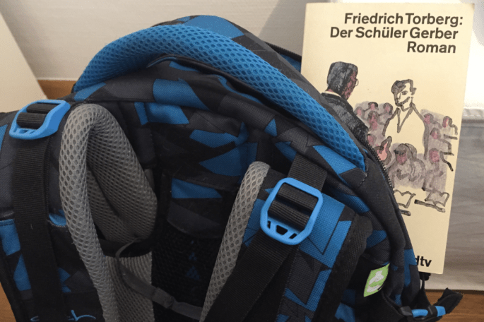 Das Bild zeigt eine Schultasche, in der Friedrich Torbergs Roman "Der Schüler Gerber" steckt.